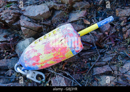 Un colorato, weathered lobster trap marcatore di boa lavato fino alla riva nel Maine. Foto Stock