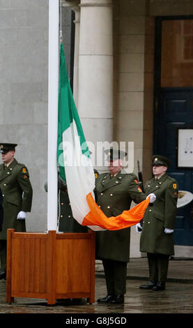 Un membro delle forze di difesa irlandesi detiene la bandiera nazionale che è stata fatta volare dal GPO su o'Connell Street durante la ribellione, in quanto il primo grande evento a segnare il centenario della rivolta del 1916 si svolge al Castello di Dublino in Irlanda. Foto Stock