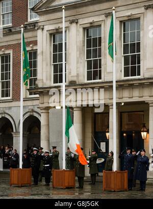 Un membro delle forze di difesa irlandesi detiene la bandiera nazionale che è stata fatta volare dal GPO su o'Connell Street durante la ribellione, in quanto il primo grande evento a segnare il centenario della rivolta del 1916 si svolge al Castello di Dublino in Irlanda. Foto Stock