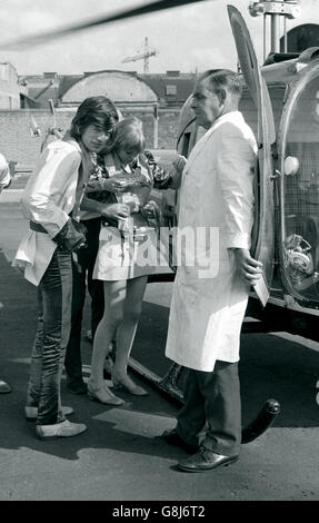 Mick Jagger, (a sinistra) dei Rolling Stones e la sua fidanzata, pop star, attrice, Marianne Faithfull, hanno i loro giubbotti di salvataggio montati prima di salire a bordo di un elicottero a Battersea Heliport. Foto Stock