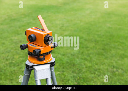 Misurazione misurazione livello di equipaggiamento transito su treppiede su erba verde Foto Stock