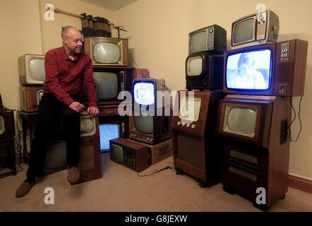 John Thompson si trova tra le parti della sua collezione di televisori vintage in bianco e nero a casa sua a Enfieldm, a nord di Londra, Migliaia di britannici hanno chiuso gli occhi sulle tendenze dei TV ad alta definizione e dei programmi in streaming sui tablet a favore del vecchio set in bianco e nero. Foto Stock