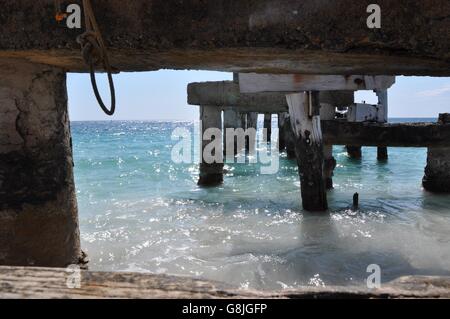 Vista da sotto il molo abbandonati nel le acque dell'Oceano Indiano a Jurien Bay sulla costa del Western Australia. Foto Stock