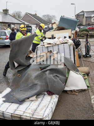 La pulizia continua quando il primo ministro Nicola Sturgeon visita alluvione colpito Port Elphinstone in Scozia, come ha annunciato un nuovo &sterlina;12 milioni di aiuti finanziari per le comunità colpite da condizioni meteorologiche avverse. Foto Stock