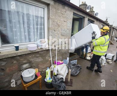 La pulizia continua quando il primo ministro Nicola Sturgeon visita alluvione colpito Port Elphinstone in Scozia, come ha annunciato un nuovo &sterlina;12 milioni di aiuti finanziari per le comunità colpite da condizioni meteorologiche avverse. Foto Stock