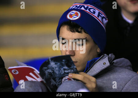 Reading v Huddersfield Town - Emirates fa Cup - Third Round Replay - Madejski Stadium. Un sostenitore della lettura legge il programma del giorno della partita prima del gioco negli stand Foto Stock