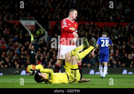 Wayne Rooney di Manchester United (a destra), il portiere del Chelsea Thibaut Courtois tiene sul pallone dopo aver fatto un salvataggio durante la partita della Barclays Premier League a Old Trafford, Manchester. Foto Stock