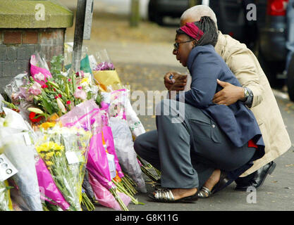 Gee Walker (al centro), madre dell'adolescente assassinato Anthony Walker, è aiutata da un membro della famiglia mentre visita il luogo in cui il suo figlio di 18 anni è stato assassinato a Huyton. Il cugino dell'adolescente nero assassinato, che era con lui poco prima dell'uccisione, disse: "Mi dispiace che non potessi fare di più per aiutarti". Marcus Binns, 17 anni, è stato con Anthony Walker quando sono stati verbalmente abusati da delinquenti razzisti a Huyton, Liverpool, il Venerdì sera. La coppia, che era con la fidanzata bianca di Anthony, si allontanò dai guai ma fu seguita attraverso un parco. Il sig. Binns e la ragazza di 17 anni sono riusciti a. Foto Stock