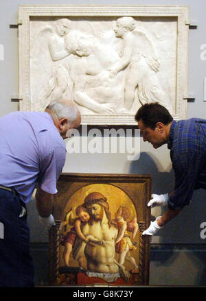 Il "Dead Cristo sostenuto da due Angeli" di Crivelli viene sollevato in posizione accanto al rilievo marmoreo di Donatello "Dead Cristo tended by Angels" che ha ispirato il dipinto. Foto Stock