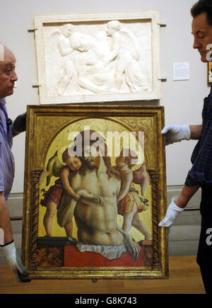 Il "Cristo papale sostenuto da due Angeli" di Crivelli viene sollevato in posizione, accanto al rilievo marmoreo di Donatello "Cristo papale tenduto dagli Angeli" che ha ispirato il dipinto. Foto Stock