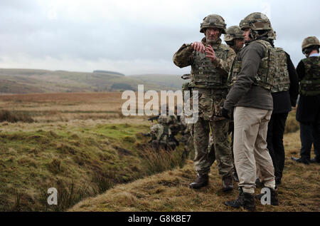 Il Ministro delle forze armate Penny Mordaunt (a destra) guarda un esercizio di fuoco dal vivo da parte dei membri della Scuola di Battaglia di Fanteria all'Area di addestramento di Sennybridge nel Beacons di Brecon, Galles. Foto Stock