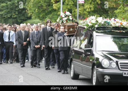 Amici e familiari portano la bara di Thomas devlin dalla sua casa alla Chiesa della Resurrezione nel Nord di Belfast. Il brutale e insensato assassinio di uno scolaro di 15 anni ha costretto molte persone a mettere in discussione ciò che è sbagliato nella società dell'Irlanda del Nord, ha detto oggi un sacerdote ai lutto. Thomas Devlin è stato pugnalato sul retro cinque volte quando è tornato a casa sua nel nord di Belfast con due amici dopo una visita a un negozio locale per acquistare dolci. Ai genitori dell'adolescente, Jim e Penny, si unirono decine di alunni della Royal Academy di Belfast per il suo servizio funerario presso la Chiesa della Risurrezione. Foto Stock