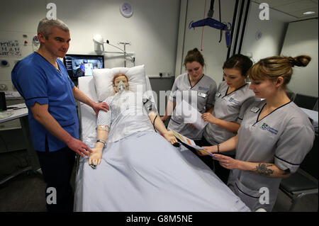 Nella foto è un medico lo scenario dell'Alexander Fairley le competenze cliniche Area con pratica educatori Kevin Lang con gli studenti infermieri Peggy Smith(secondo da sinistra), Alexandra McKinstry ed Emma Kristoffersen(lontano a destra) che effettuano una visita medica di scenario utilizzando un manichino presso la Queen Elizabeth University Hospital di Glasgow, Nicola Storione girato anche laboratori medici dove gli studenti stanno lavorando su nuovi modi per estrarre il DNA per fornire un trattamento personalizzato per i pazienti. Foto Stock