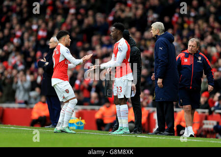 Danny Welbeck dell'Arsenal è sostituito da Alex Oxlade-Chamberlain dell'Arsenal (A sinistra) come il manager Arsenal Arsene Wenger (seconda a destra) guarda sopra Foto Stock