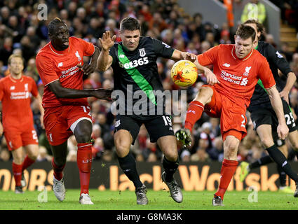 Mamadou Sakho di Liverpool (a sinistra) e James Milner a destra) combattono per la palla con Jonathan Walters di Stoke City durante la Capital One Cup, semifinale, seconda tappa ad Anfield, Liverpool. Foto Stock