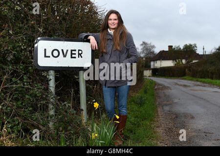 Residente locale e attivista Katie Gibbs si pone accanto a un segno per il villaggio amante nel Wiltshire, come i residenti hanno inviato un appello di San Valentino per l'aiuto nel loro tentativo di riportare la vita nella loro casa rurale. Foto Stock