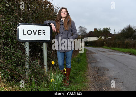 Residente locale e attivista Katie Gibbs si pone accanto a un segno per il villaggio amante nel Wiltshire, come i residenti hanno inviato un appello di San Valentino per l'aiuto nel loro tentativo di riportare la vita nella loro casa rurale. Foto Stock