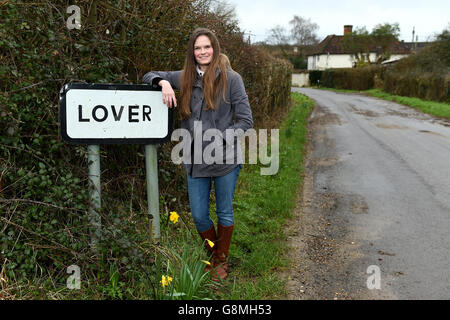 Residente locale e attivista Katie Gibbs si pone accanto a un segno per il villaggio amante nel Wiltshire, come i residenti hanno inviato un appello di San Valentino per l'aiuto nel loro tentativo di riportare la vita nella loro casa rurale. Foto Stock