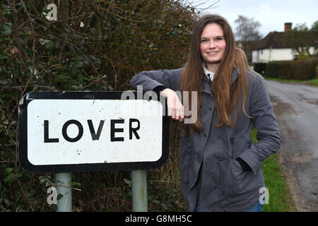 Residente locale e attivista Katie Gibbs si pone accanto a un segno per il villaggio amante nel Wiltshire, come i residenti hanno inviato un appello di San Valentino per l'aiuto nel loro tentativo di riportare la vita nella loro casa rurale. Foto Stock