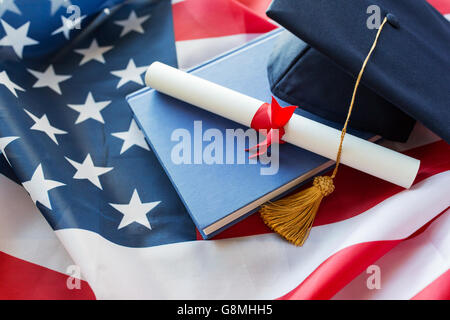 Corso di laurea hat e diploma sulla bandiera americana Foto Stock
