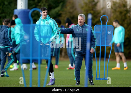 Il manager provvisorio di Chelsea Guus Hiddink (a destra) con il portiere Thibaut Courtois durante la sessione di allenamento al Cobham Training Ground, Londra. Foto Stock