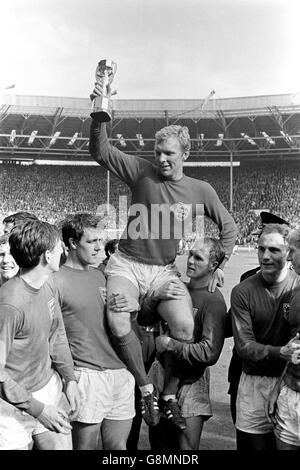 Il capitano dell'Inghilterra Bobby Moore tiene la Coppa del mondo in aloft mentre è presieduto dai suoi compagni di squadra giubilanti: (l-r) Martin Peters, Geoff Hurst, Moore, Ray Wilson, George Cohen, Bobby Charlton Foto Stock