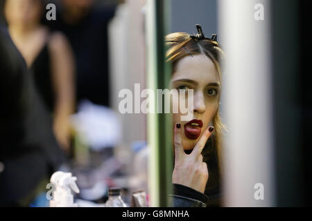 Gesto DI NOTA EDS UN modello di gesti per il fotografo mentre si prepara sul backstage prima del Mary Katrantzou Autunno/Inverno 2016 London Fashion Week show all'Università delle Arti di Londra, Central St Martins, Londra. Foto Stock
