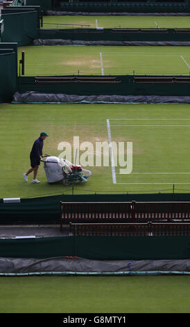 Il personale di terra utilizzare un'erba vuoto sul numero di corte 10 il giorno tre i campionati di Wimbledon al All England Lawn Tennis e Croquet Club, Wimbledon. Foto Stock