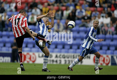 Anthony le Tallec (L) di Sunderland spara sotto pressione da Graham Kavanagh di Wigan Athletics durante la partita fa Barclays Premiership allo stadio JJB di Wigan, sabato 27 agosto 2005. PREMERE ASSOCIAZIONE foto. Il credito fotografico deve essere: Dave Thompson/PA. Foto Stock