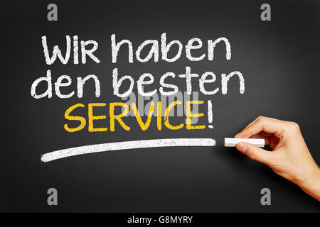 Scrive a mano in tedesco "Wir haben den besten Service!" (offriamo il miglior servizio!) sulla lavagna Foto Stock