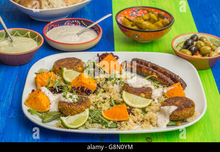 La quinoa con arrosti di zucca, falafel e salsicce. Condito con salsa alla menta fresca e crescione Foto Stock