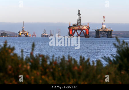 Una piattaforma petrolifera si trova tra gli altri carri che sono stati lasciati nel Cromarty Firth vicino Invergordon nelle Highlands della Scozia. Le piattaforme di perforazione sono state accatastate nel Cromarty Firth mentre i prezzi del petrolio continuano a diminuire, avendo un impatto importante sull'industria petrolifera del Mare del Nord del Regno Unito, lasciando migliaia di persone fuori lavoro. Foto Stock