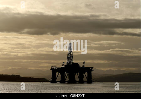 Una piattaforma petrolifera si trova tra gli altri carri che sono stati lasciati nel Cromarty Firth vicino Invergordon nelle Highlands della Scozia. Le piattaforme di perforazione sono state accatastate nel Cromarty Firth mentre i prezzi del petrolio continuano a diminuire, avendo un impatto importante sull'industria petrolifera del Mare del Nord del Regno Unito, lasciando migliaia di persone fuori lavoro. Foto Stock