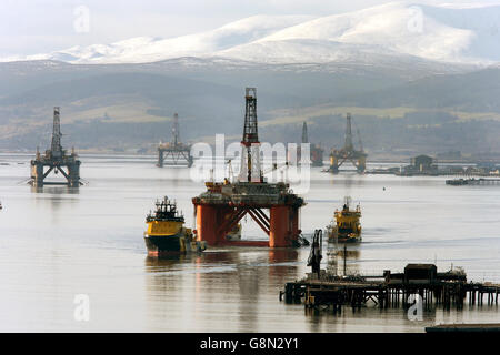 La piattaforma petrolifera Stena Spey è spostata con le barche di rimorchiatore tra gli altri carri che sono stati lasciati nel Cromarty Firth vicino Invergordon nelle Highlands della Scozia. Le piattaforme di perforazione sono state accatastate nel Cromarty Firth mentre i prezzi del petrolio continuano a diminuire, avendo un impatto importante sull'industria petrolifera del Mare del Nord del Regno Unito, lasciando migliaia di persone fuori lavoro. Foto Stock