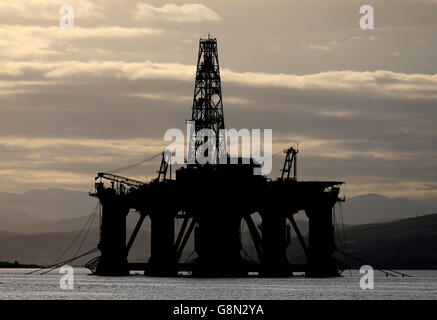 Una piattaforma petrolifera si trova tra gli altri carri che sono stati lasciati nel Cromarty Firth vicino Invergordon nelle Highlands della Scozia. Le piattaforme di perforazione sono state accatastate nel Cromarty Firth mentre i prezzi del petrolio continuano a diminuire, avendo un impatto importante sull'industria petrolifera del Mare del Nord del Regno Unito, lasciando migliaia di persone fuori lavoro. Foto Stock