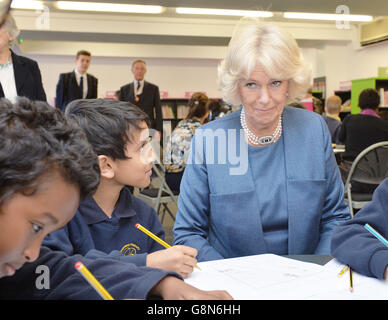 La Duchessa di Cornovaglia con i bambini che disegnano i propri libri di storia di tipo cartoon durante una visita alla biblioteca centrale di Islington, Londra. Foto Stock