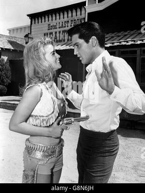 Elvis Presley ha una pistola giocosamente rivolta a lui dalla co-star Ann-Margret sul set dell'ultima foto di MGM, 'Viva Las Vegas'. Foto Stock