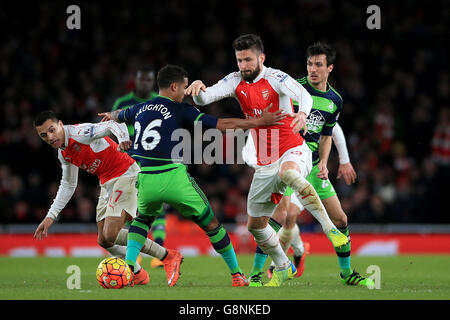 Olivier Giroud (a destra) e Alexis Sanchez (a sinistra) dell'Arsenal combattono per la palla con Kyle Naughton di Swansea City durante la partita della Barclays Premier League all'Emirates Stadium di Londra. Foto Stock