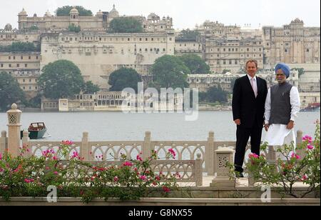 Il primo ministro britannico Tony Blair (L) si trova con il primo ministro indiano Manmohan Singh nei giardini dell'Udaivilas Hotel a Udaipur, a seguito di un incontro bilaterale. Il Palace Hotel, una volta sede della famiglia Udaipur Maharana (reale), è visto sullo sfondo. Foto Stock