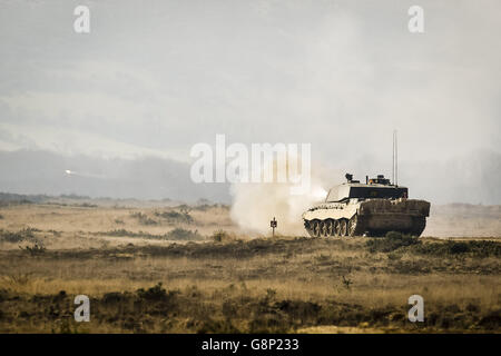 Un tracciatore rotondo spara da un carro armato principale di battaglia Challenger II durante il fuoco dal vivo alla gamma di fucileria di Lulworth, Dorset, dove i Reservisi dell'esercito della Royal Wessex Yeomanry (RWxY) si stanno allenando come parte della forza di reazione del Regno Unito. Foto Stock