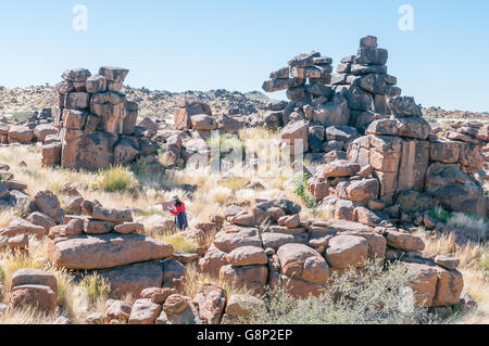 KEETMANSHOOP, NAMIBIA - 15 Maggio 2011: un artista non identificato al lavoro tra le formazioni rocciose a giganti parco giochi Foto Stock