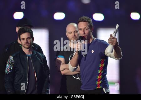 Chris Martin (a destra) di Coldplay raccoglie il British Group Award sul palco durante i Brit Awards 2016 all'O2 Arena di Londra. Foto Stock