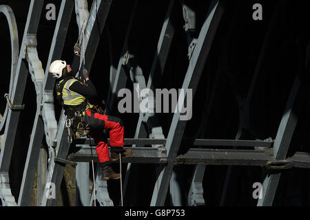 Un geometra abseils fuori del ponte di ferro sopra il fiume Severn nello Shropshire. Foto Stock