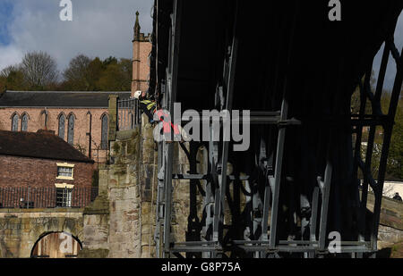 Un geometra abseils fuori del ponte di ferro sopra il fiume Severn nello Shropshire. Foto Stock