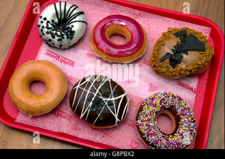 Krispy Kreme selezione di ciambelle con vari rivestimenti dolce. Un REGNO UNITO dessert dessert dolci dolci di pasticceria torte cake ciambella Foto Stock