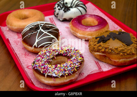 Krispy Kreme selezione di ciambelle con vari rivestimenti dolce. Un REGNO UNITO dessert dessert dolci dolci di pasticceria torte cake ciambella Foto Stock