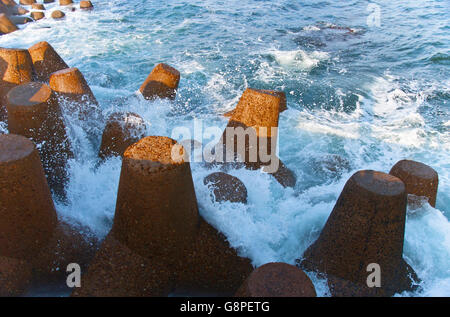 Blu oceano onde che si infrangono sulle rocce Shore Foto Stock