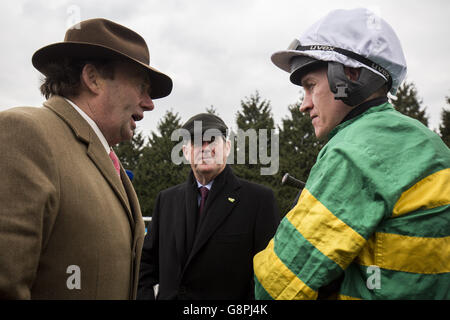 Il formatore Nicky Henderson (a sinistra) e il proprietario JP McManus (al centro) parlano con il jockey Barry Geraghty prima che My Tent o Yours lavorassero in pista durante il BetBright Chase Day all'ippodromo di Kempton Park, Middlesex. Foto Stock