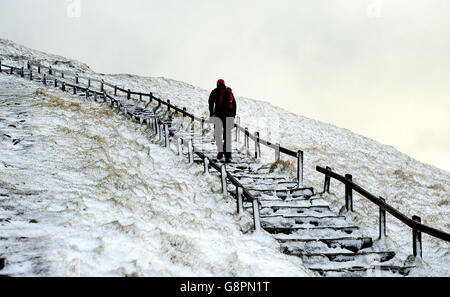 Un camminatore fa il loro senso attraverso la neve durante la notte in Buxton, Derbyshire, come i previsori hanno detto che il Jake di Storm può portare il ghiaccio, la neve e i venti di 70 mph. Foto Stock