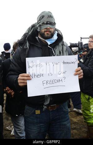 I migranti protestano mentre continuano le demolizioni nel campo migrante di Calais, noto come la giungla, nella Francia settentrionale. Foto Stock